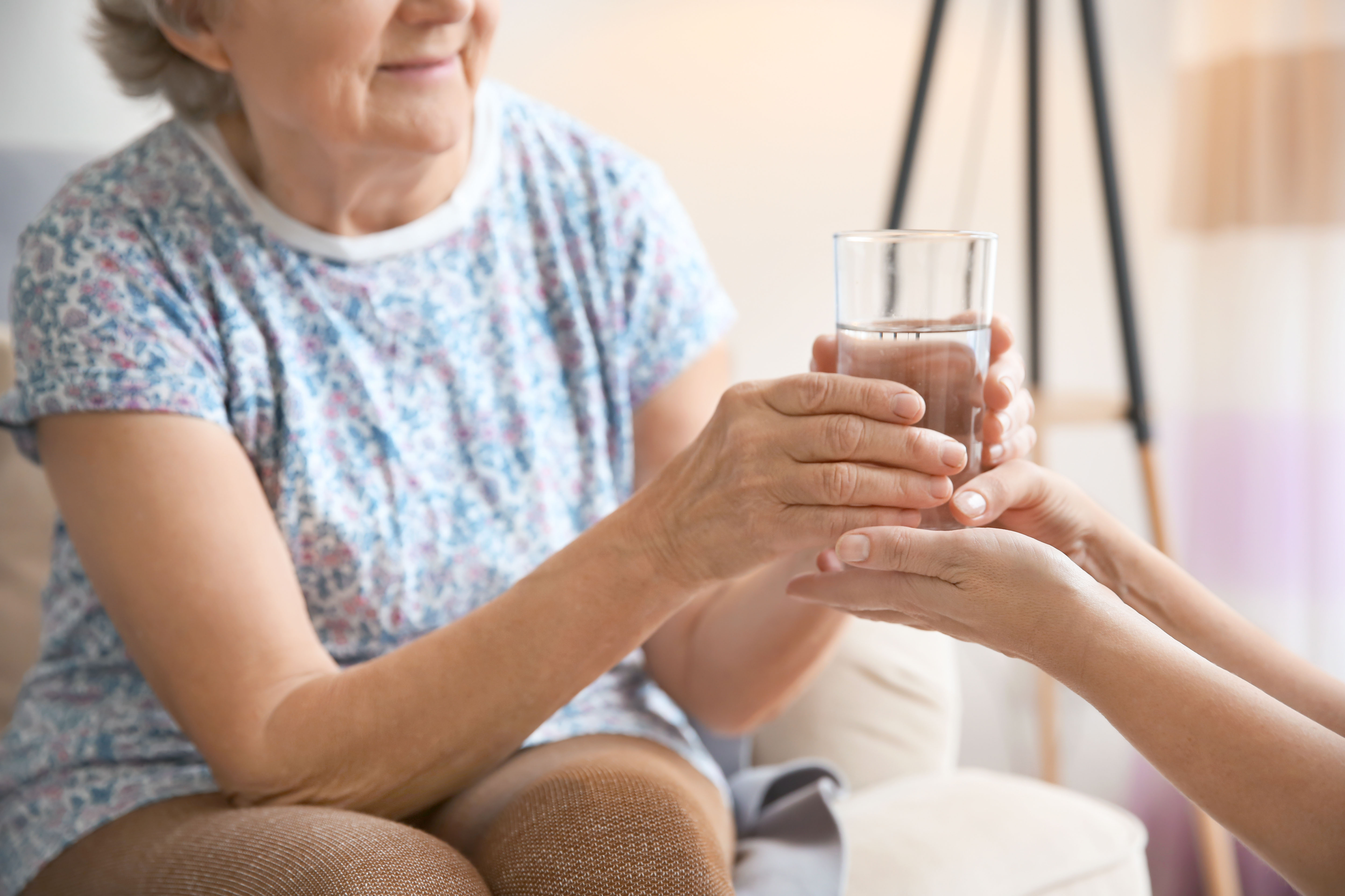 una persona da un vaso a una anciana