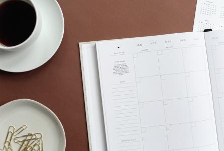 agenda abierta sobre una mesa con un café