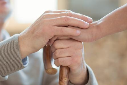 una persona da la mano a un anciano